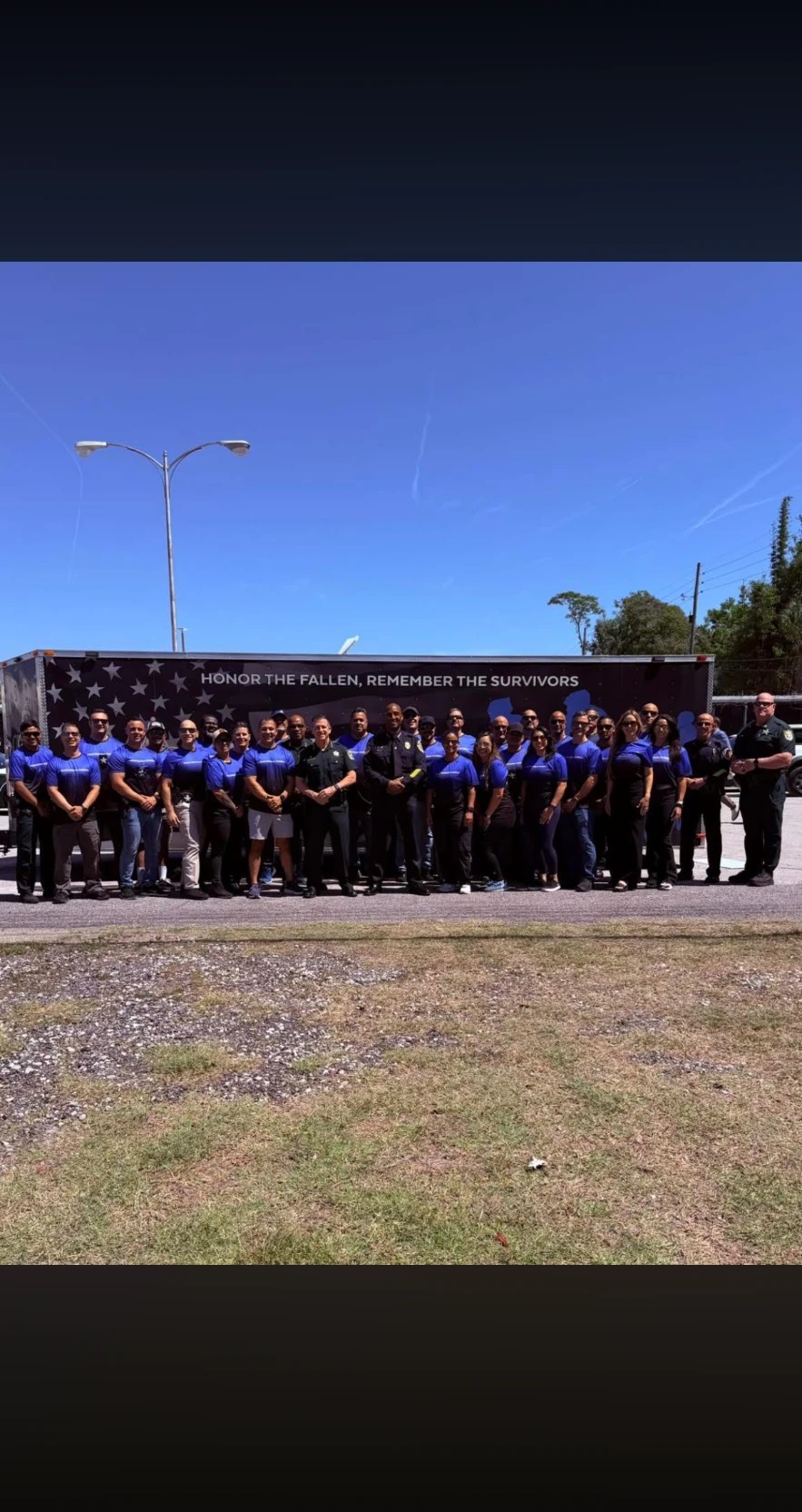 Team Central Florida gathered in front of the memorial trailer reading Honor the Fallen, Remember the Survivors